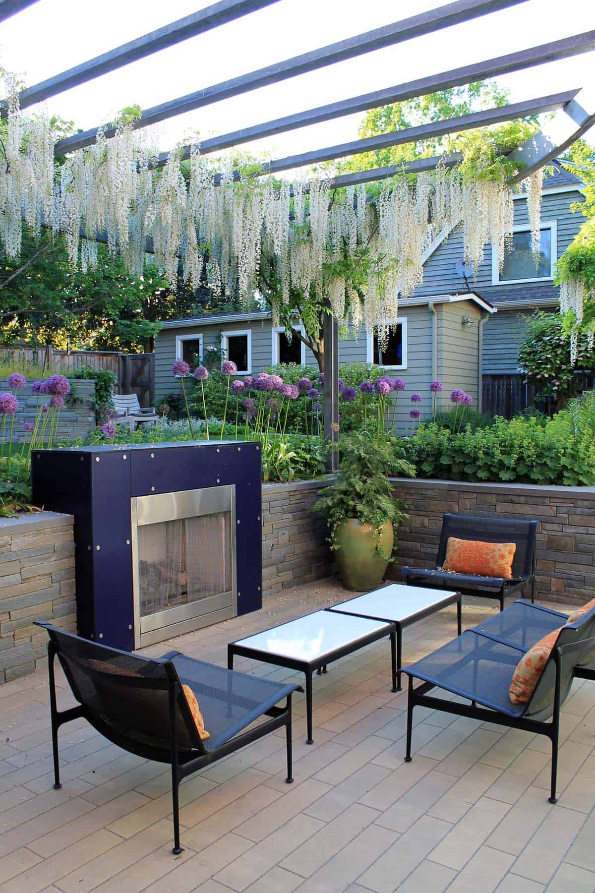 Modern navy fireplace on a contemporary patio with wisteria pergola