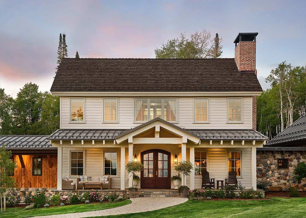 White farmhouse facade with covered porch and brick chimney