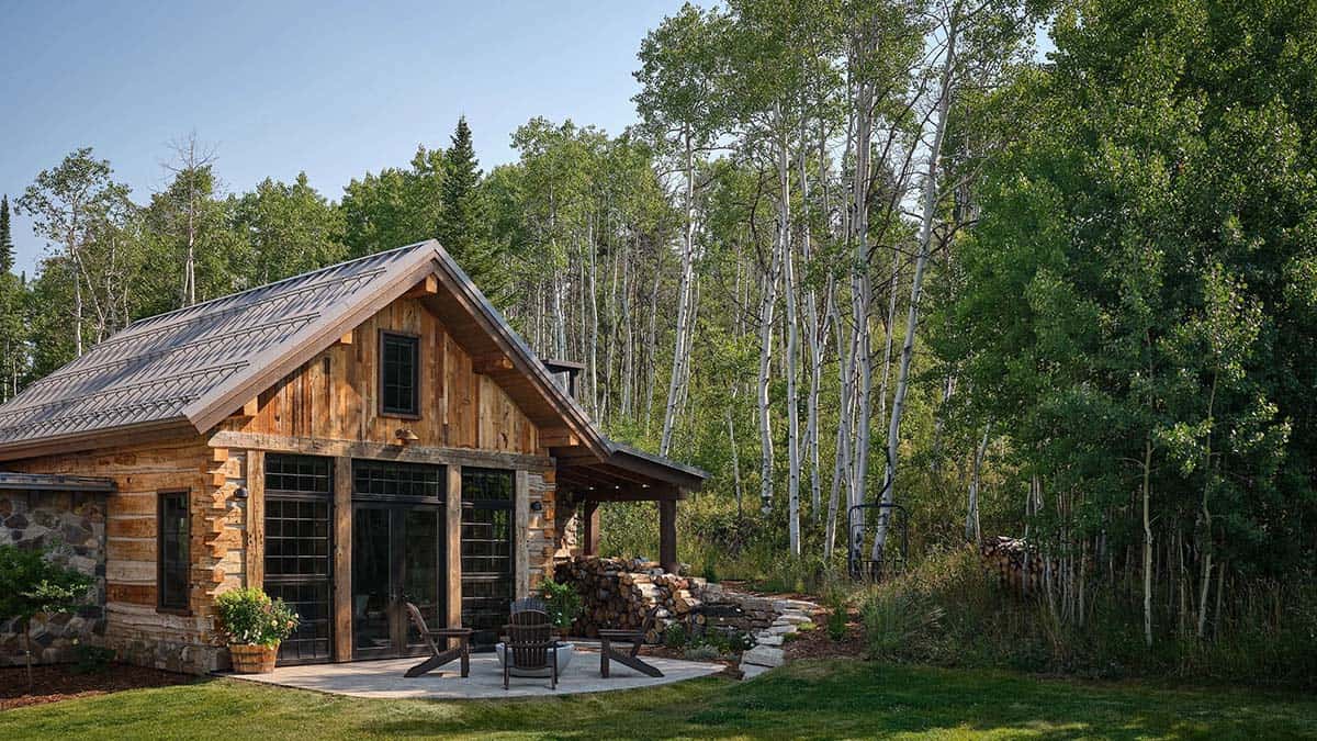 Reclaimed log guest cabin exterior nestled among aspen trees