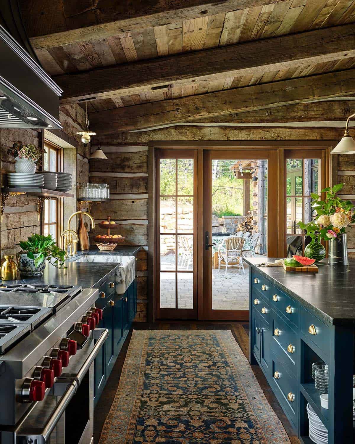 Kitchen with reclaimed log walls and navy blue cabinetry