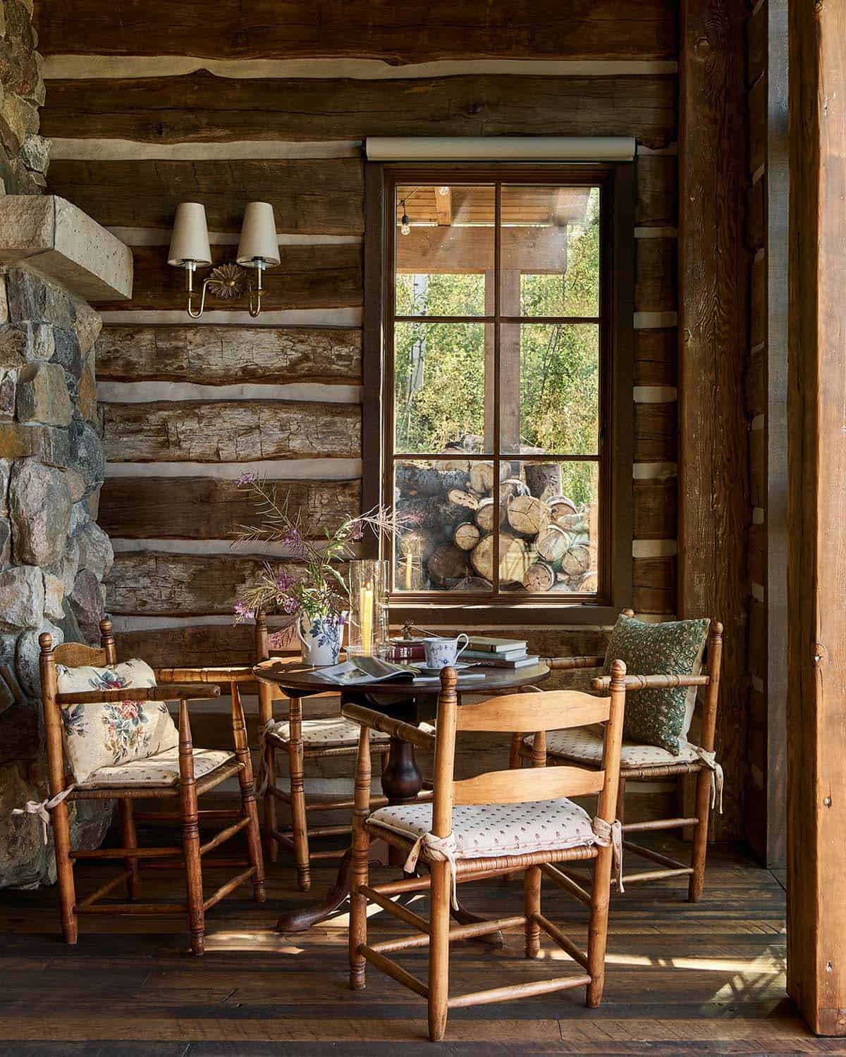 Cozy breakfast nook with vintage chairs by log wall