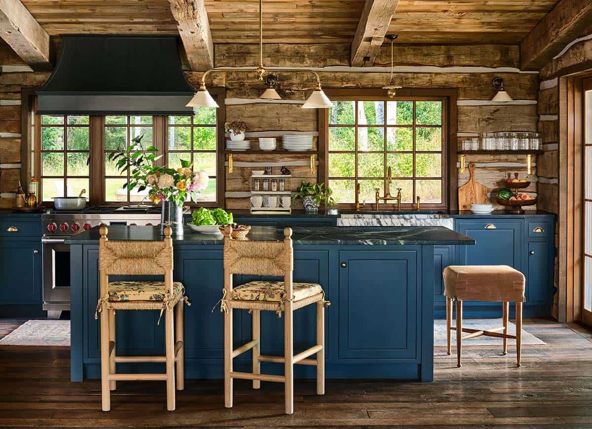 Kitchen island with navy cabinetry and woven counter stools