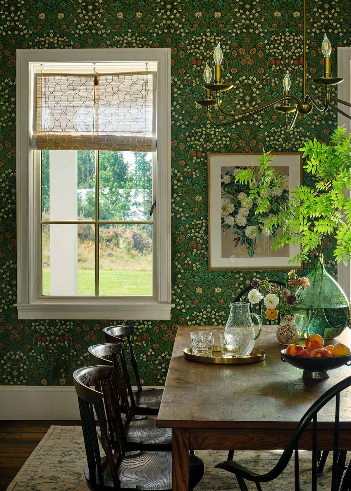 Dining nook with green floral wallpaper and demijohn vase