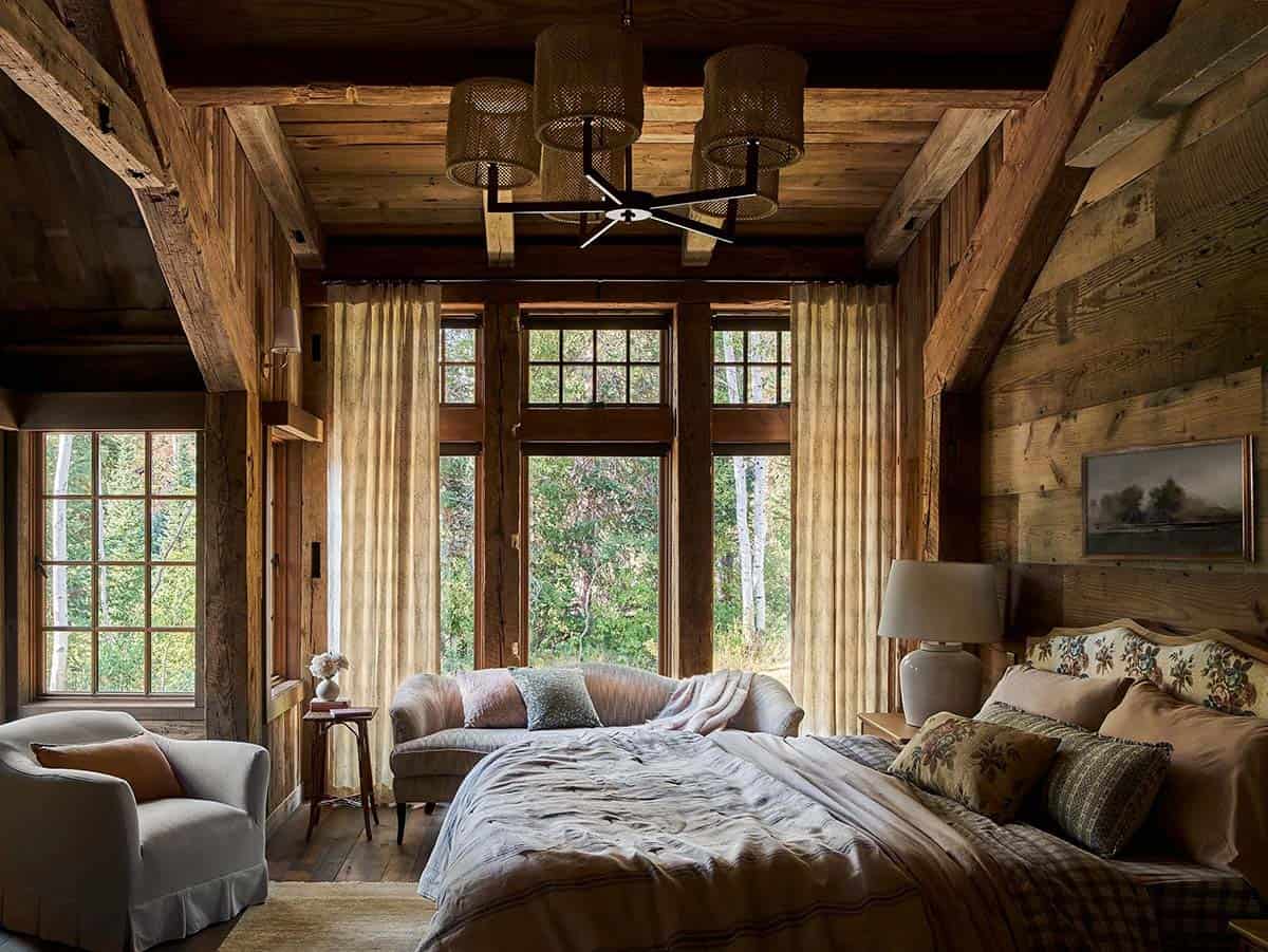 Rustic primary bedroom with vaulted ceiling and floral accent pillows