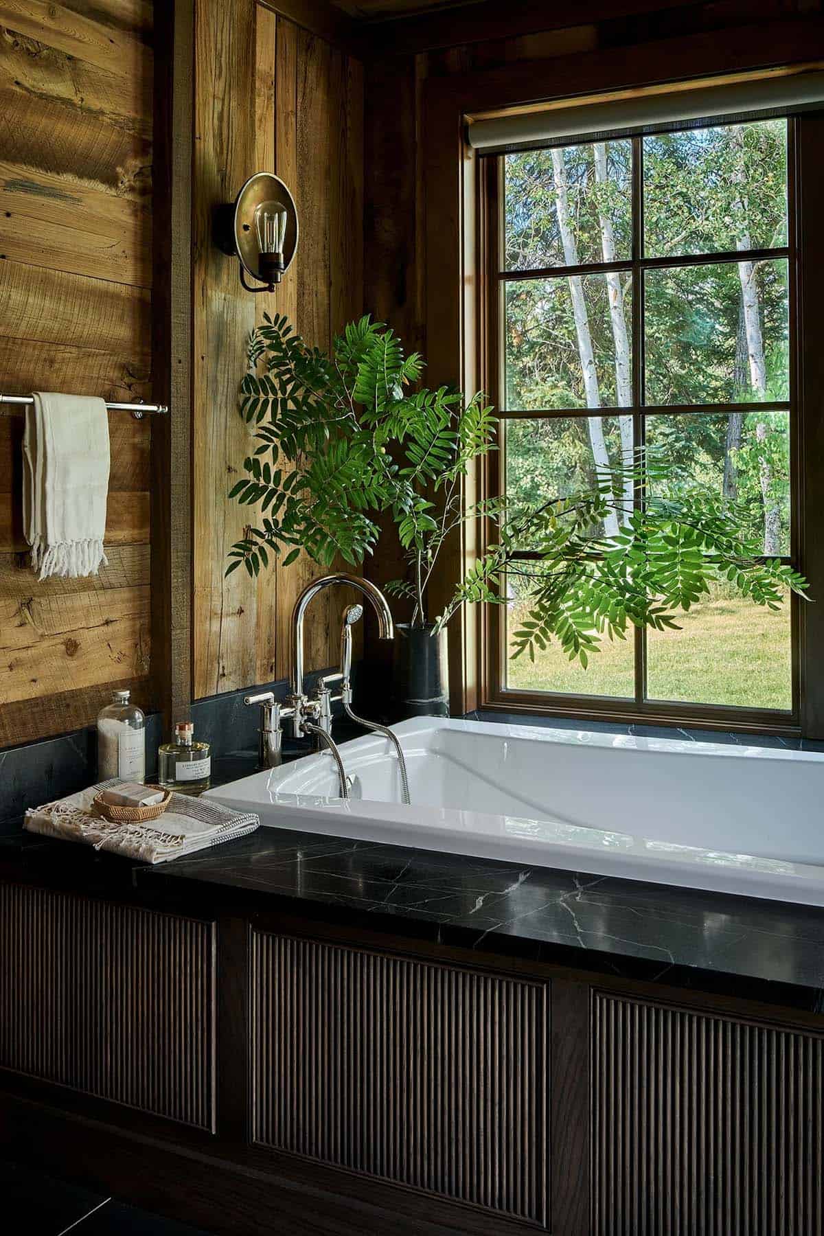 Soaking tub with black soapstone surround beside window