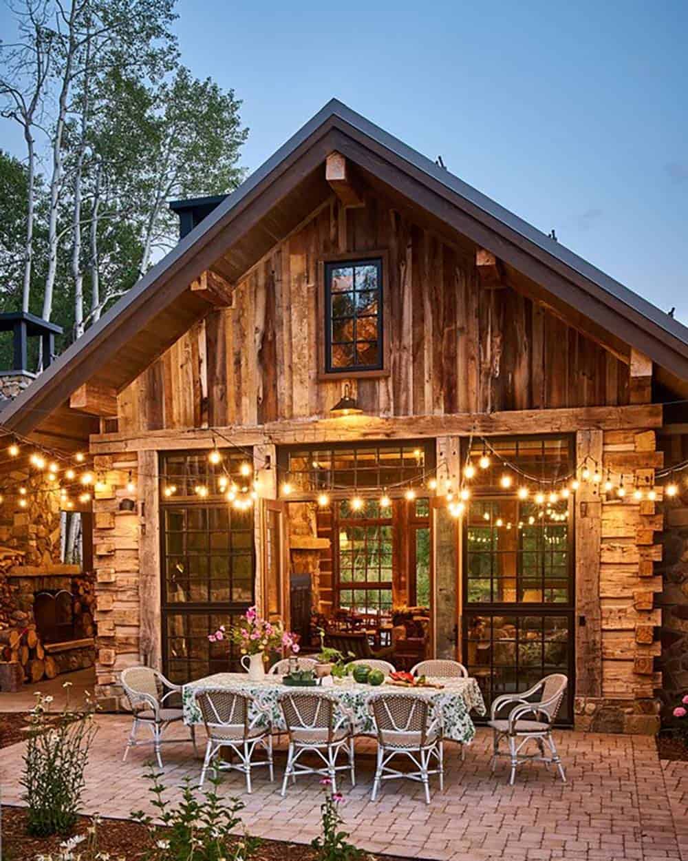 Reclaimed wood cabin exterior with string lights at dusk