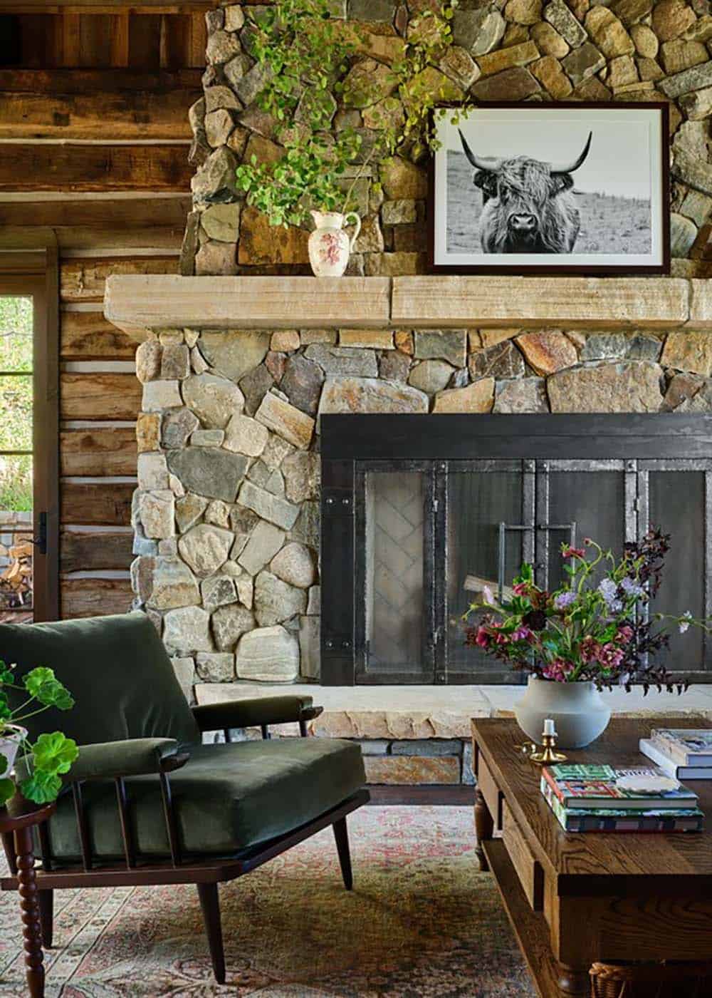 Stone fireplace with highland cow print and green armchair