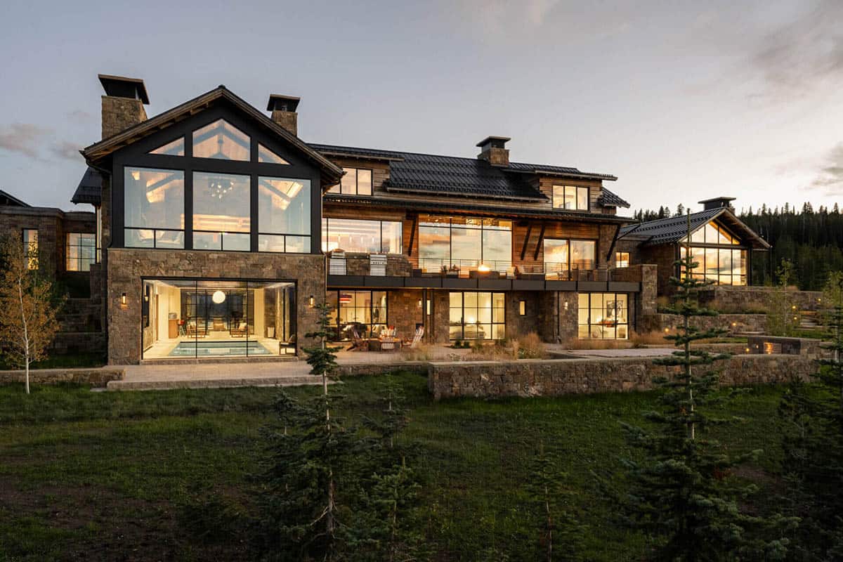 Rear facade at dusk with glowing windows and mountain views