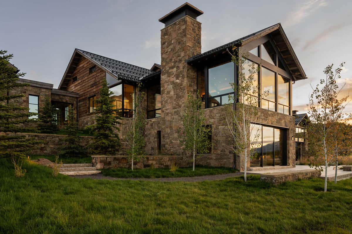 Stone chimney and glass gable detail at dusk