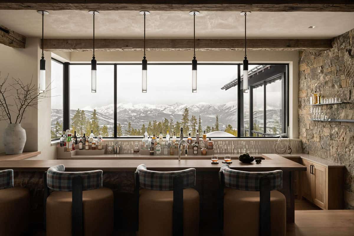 Wet bar with pendant lights overlooking snow-covered mountain range