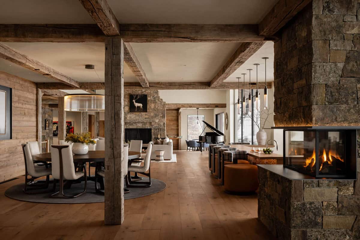 Open-concept dining and living area with exposed timber beams