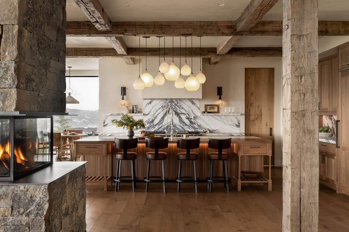 Kitchen island with cluster pendant lighting and marble backsplash