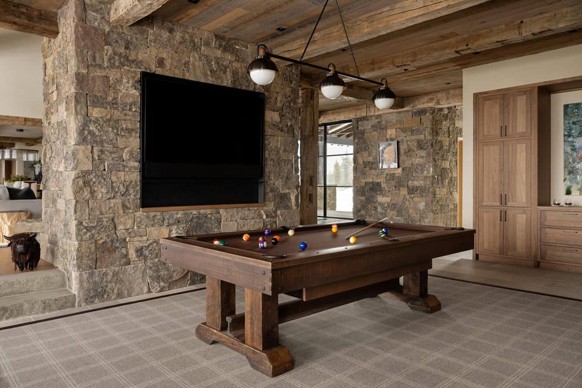 Game room with pool table and stone accent wall