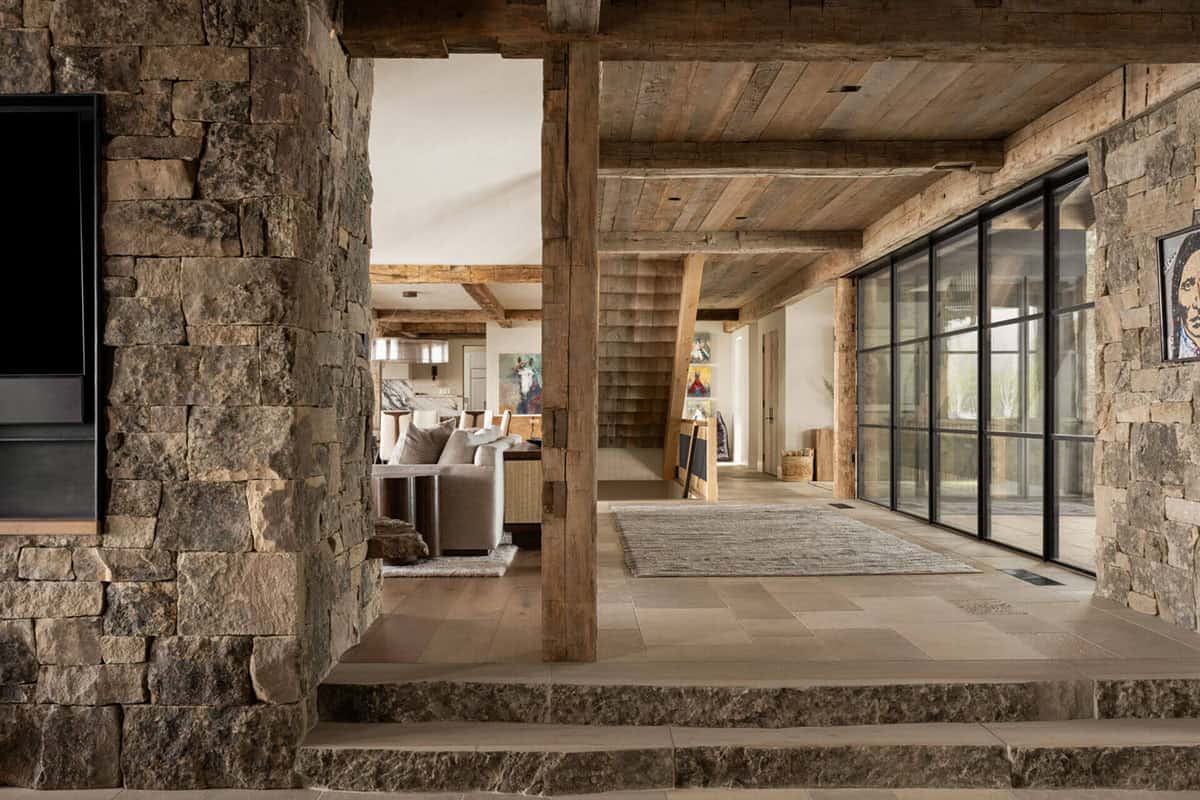 Open hallway with stone columns and glass wall to patio