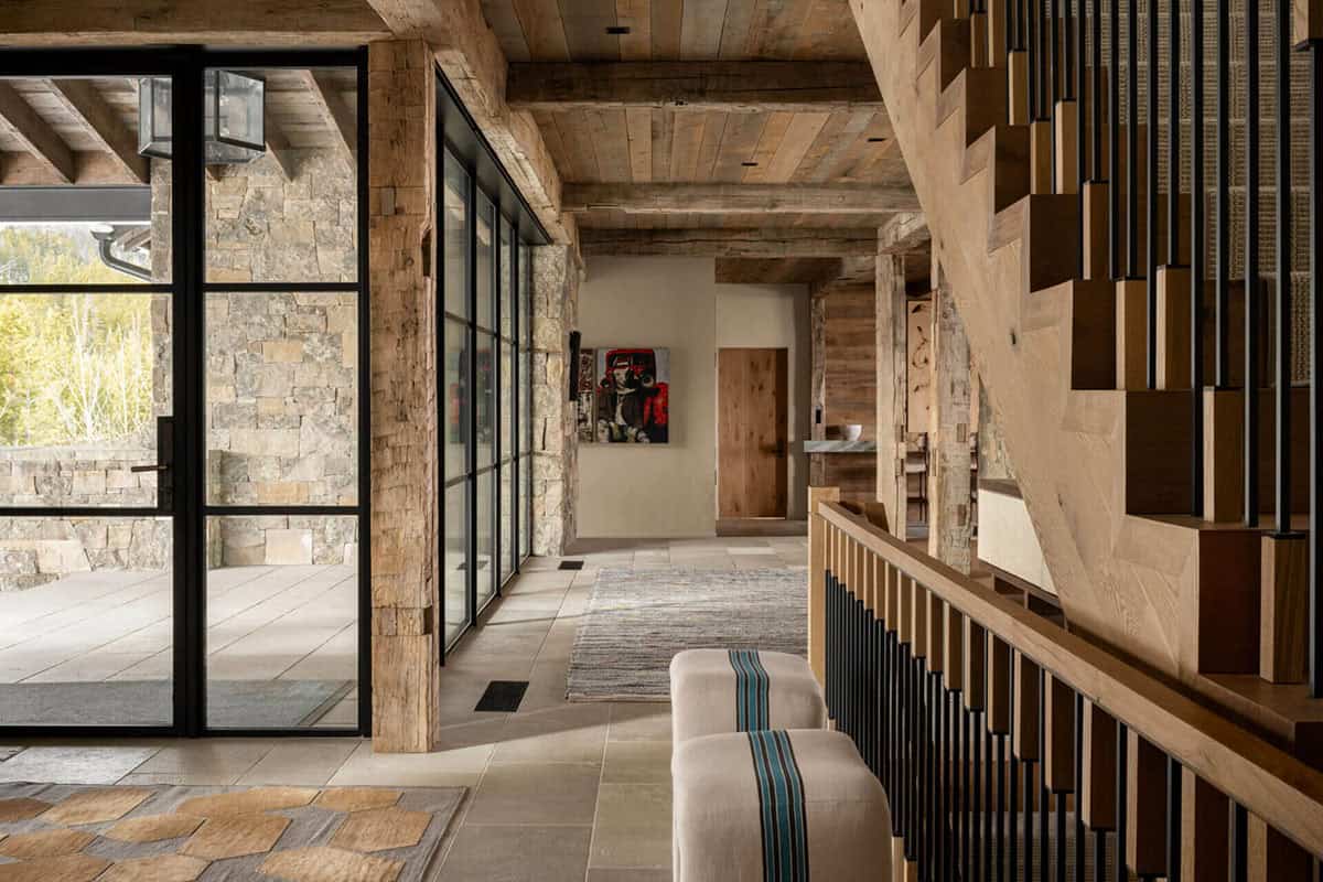 Entry foyer with rustic stairwell and glass door to outdoors
