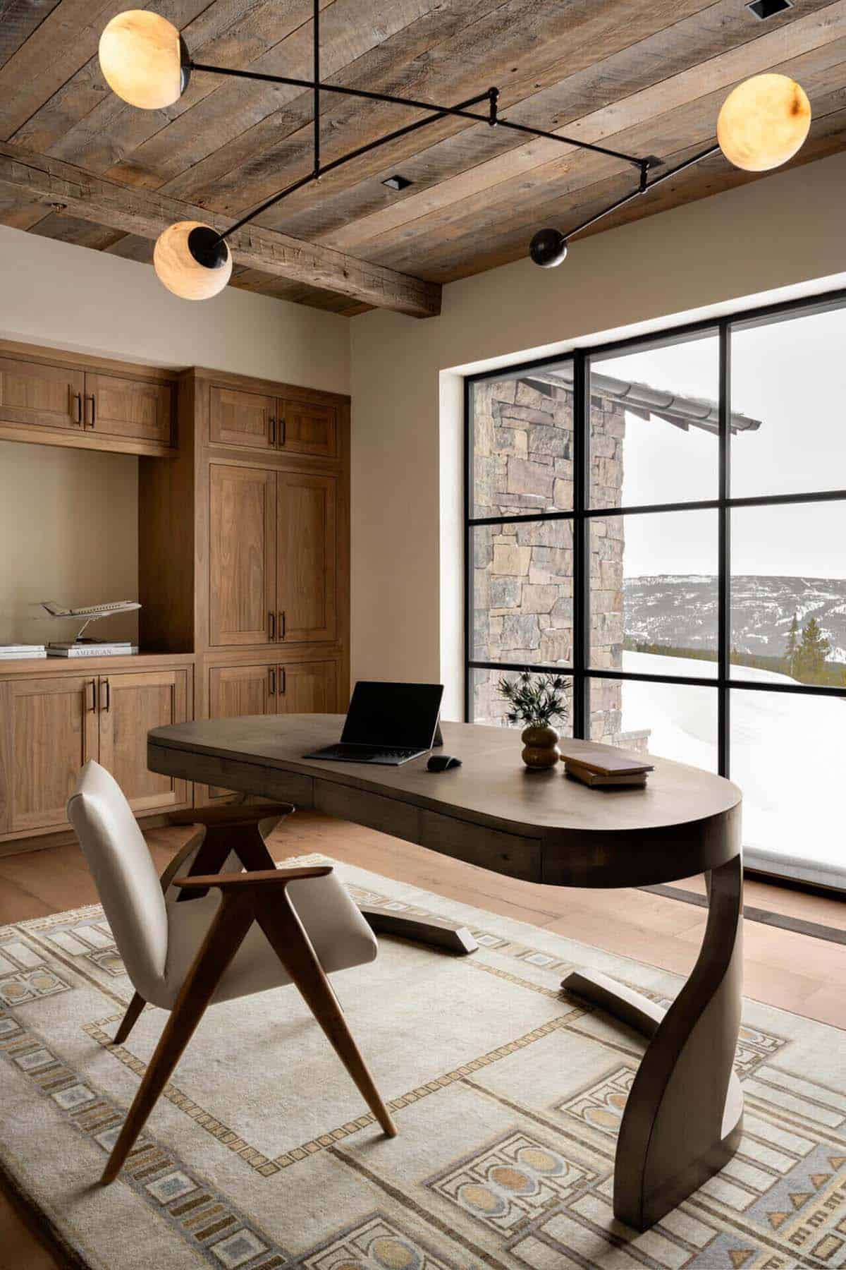Home office with sculptural desk and orb chandelier fixture