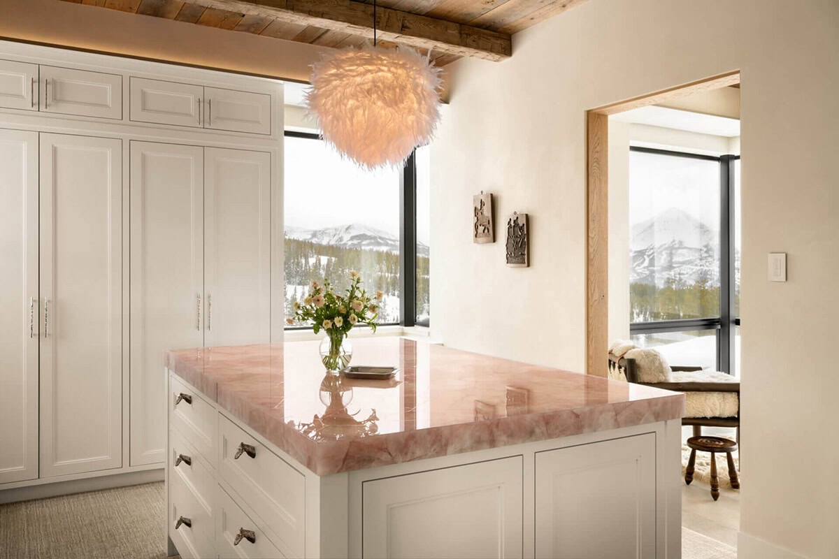 Powder room vanity with pink onyx countertop and white cabinetry