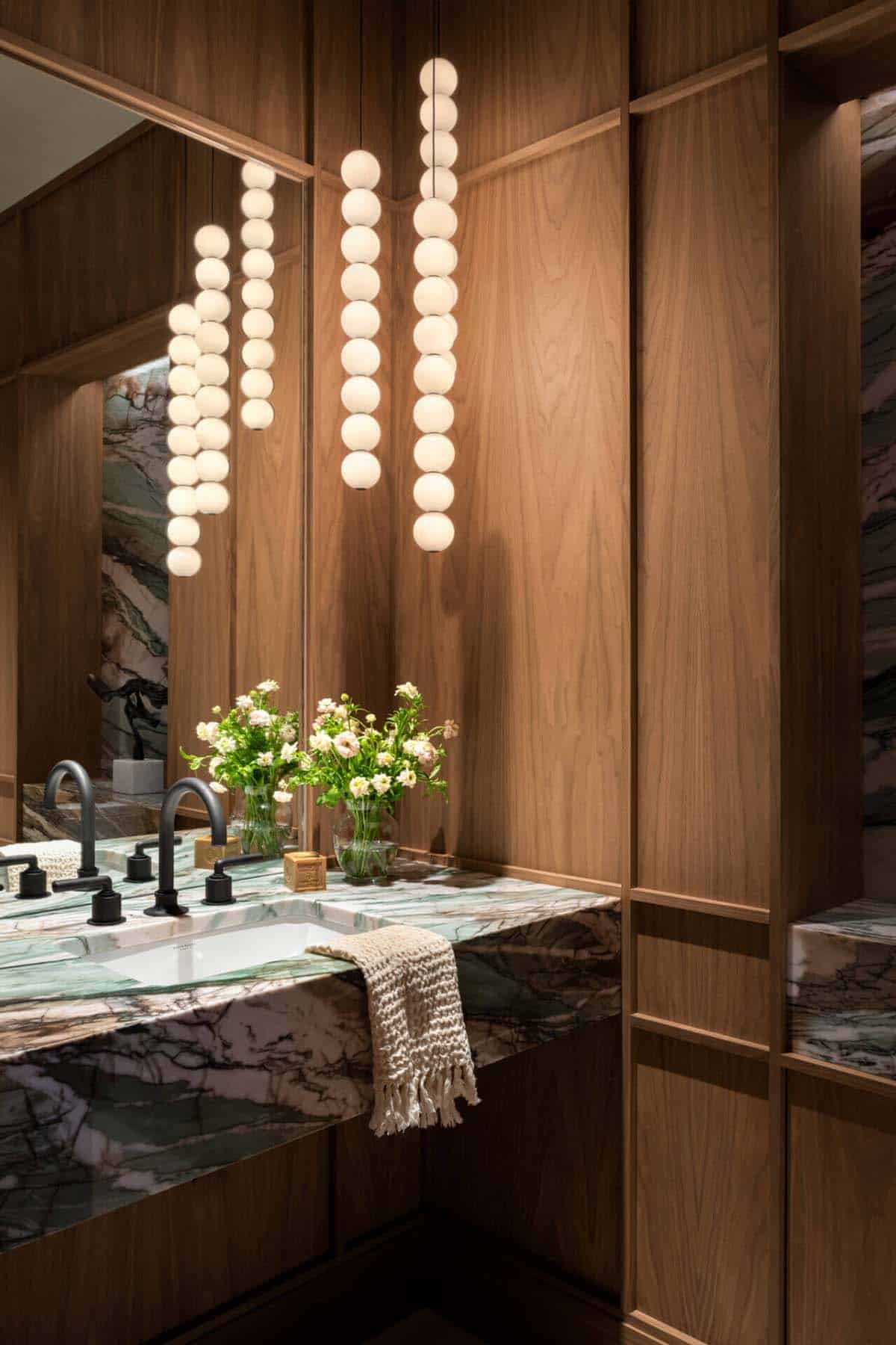 Bathroom vanity with green marble counter and globe pendants