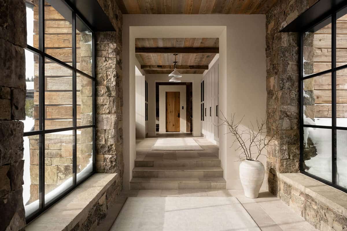 Rustic entry corridor leading to front door and steps