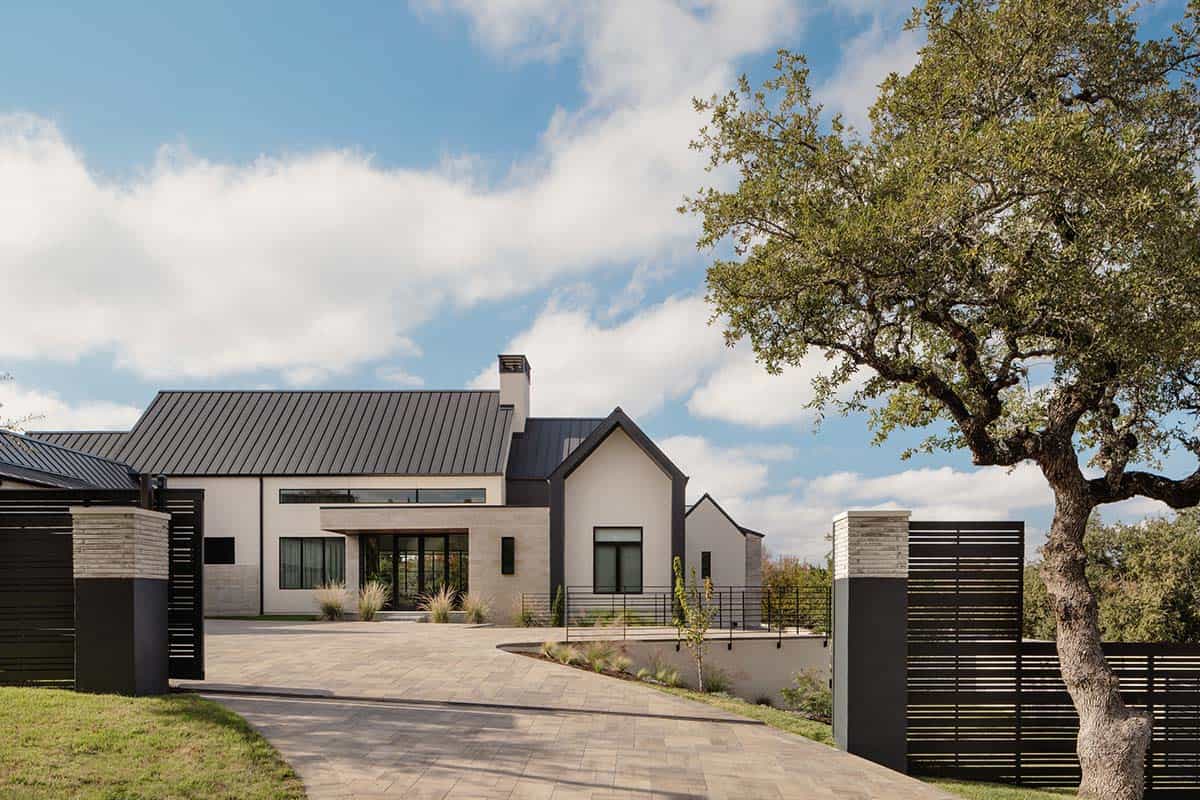 Scandinavian exterior home with black metal gate and mature oak tree
