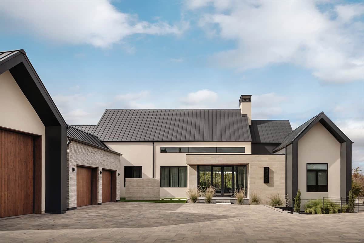 Board-formed concrete accent wall between garage and stone entry facade