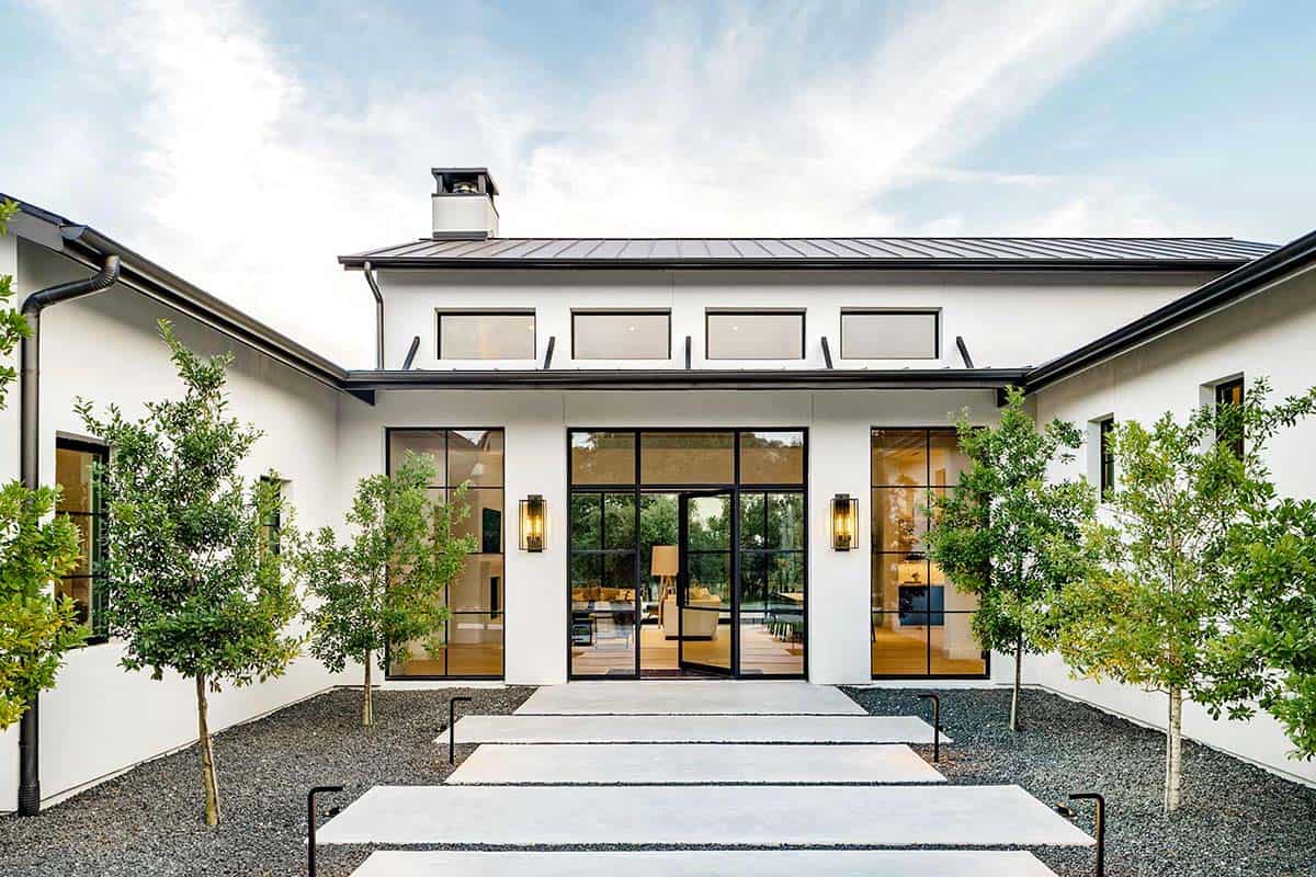 Courtyard entry with steel and glass doors flanked by young trees