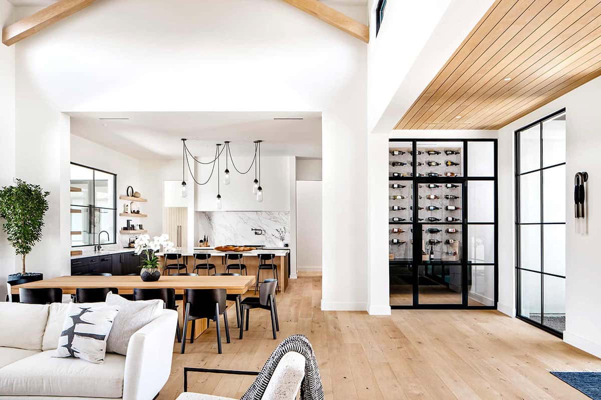 Open living and dining area with glass-enclosed wine room beyond