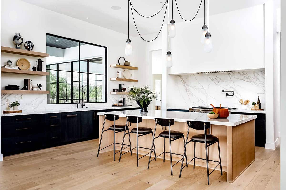 Kitchen with black cabinetry, marble slab backsplash, and floating shelves