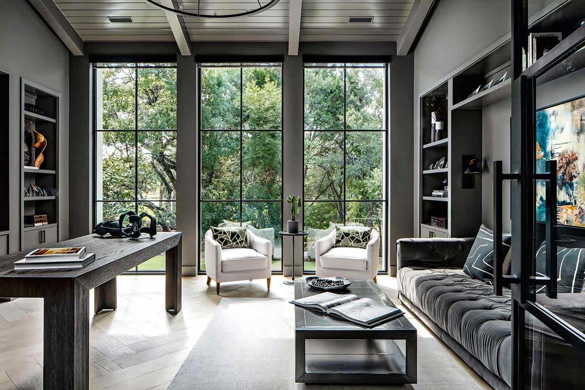 Moody home office with floor-to-ceiling steel windows and built-in shelving