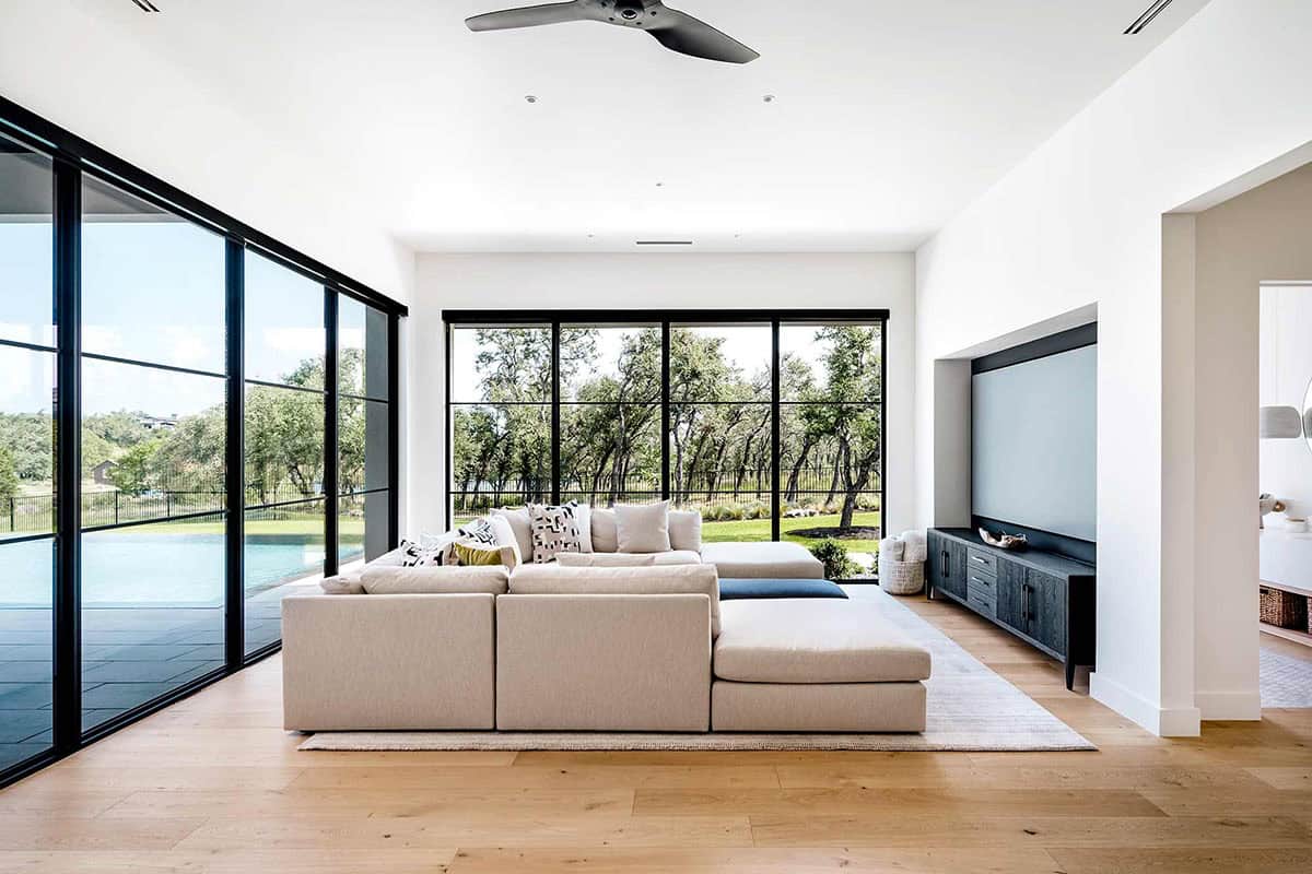Family room sectional facing steel-framed windows and pool view