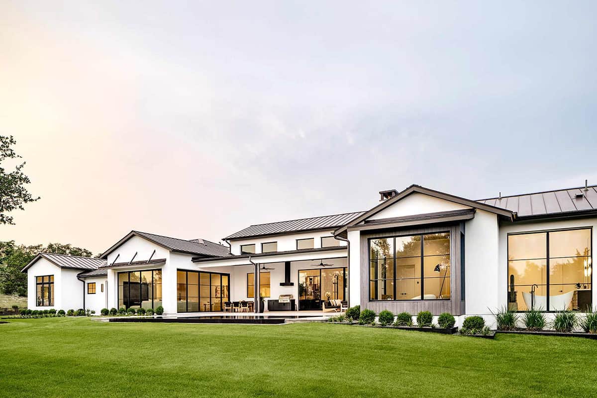 Home exterior backyard view with illuminated windows