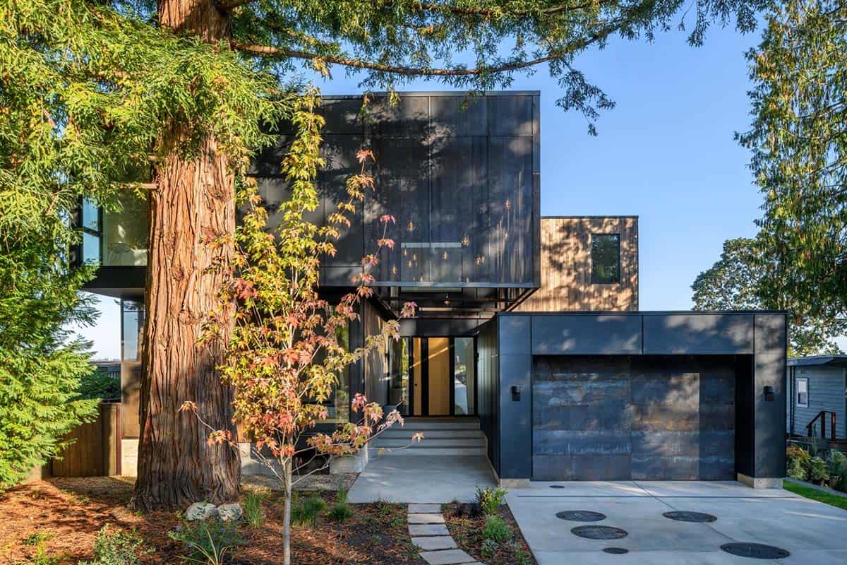 Black metal facade with corten garage door among fall foliage
