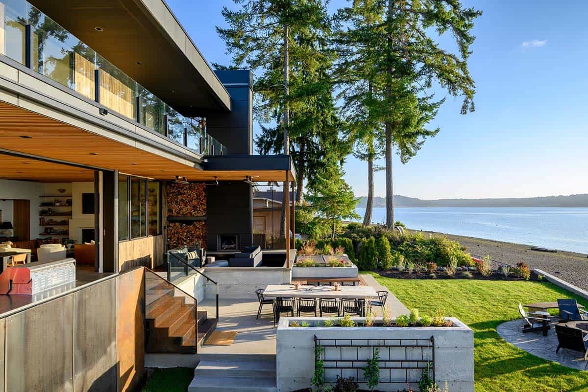 Covered patio and firepit lawn overlook beach and evergreen trees