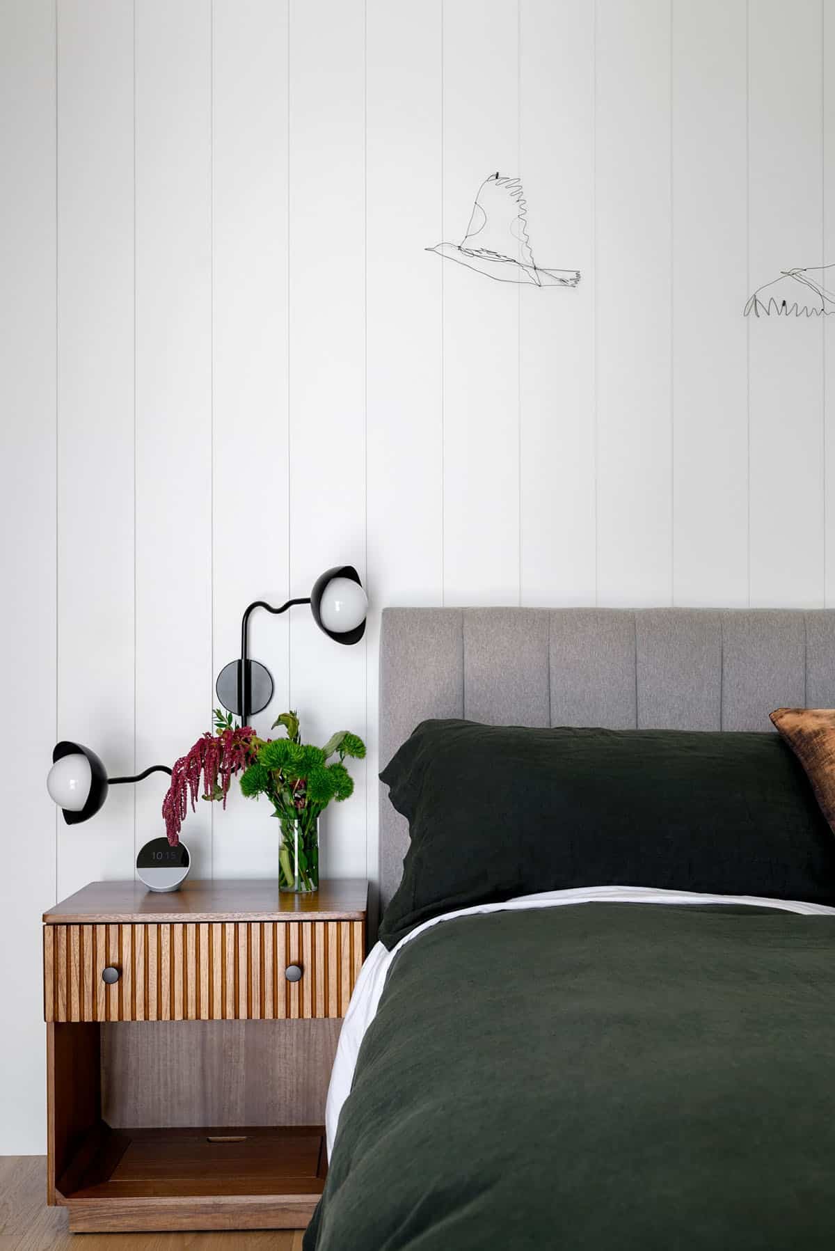 Bedroom headboard with wire bird art and sculptural wall sconces