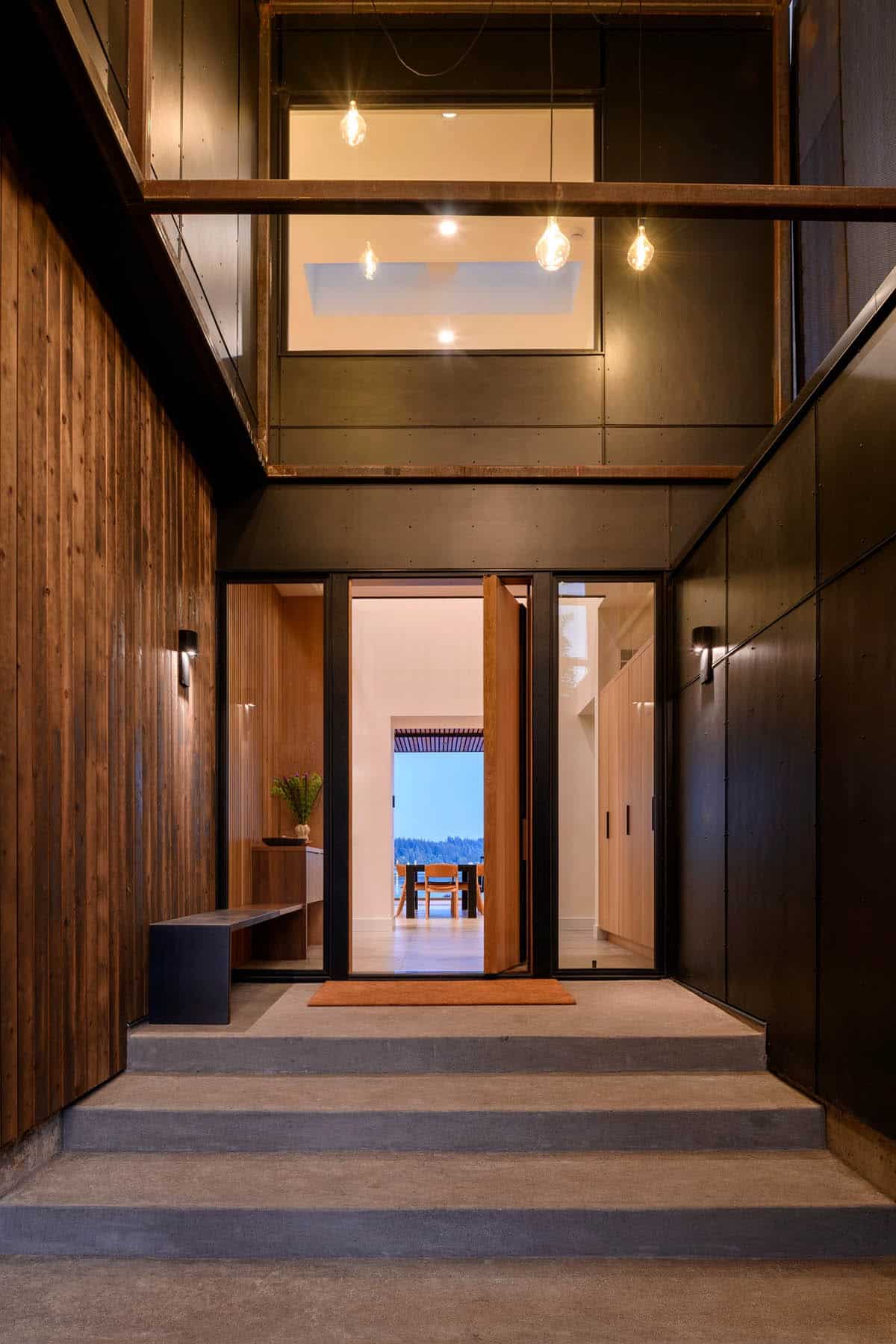 Entry foyer at dusk with pendant lights and open front door