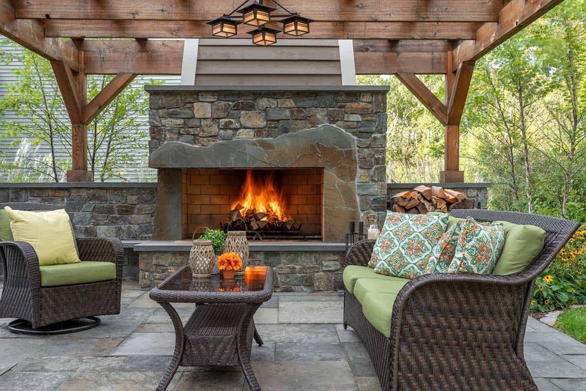 Stone fireplace with mountain-shaped mantel on a covered patio