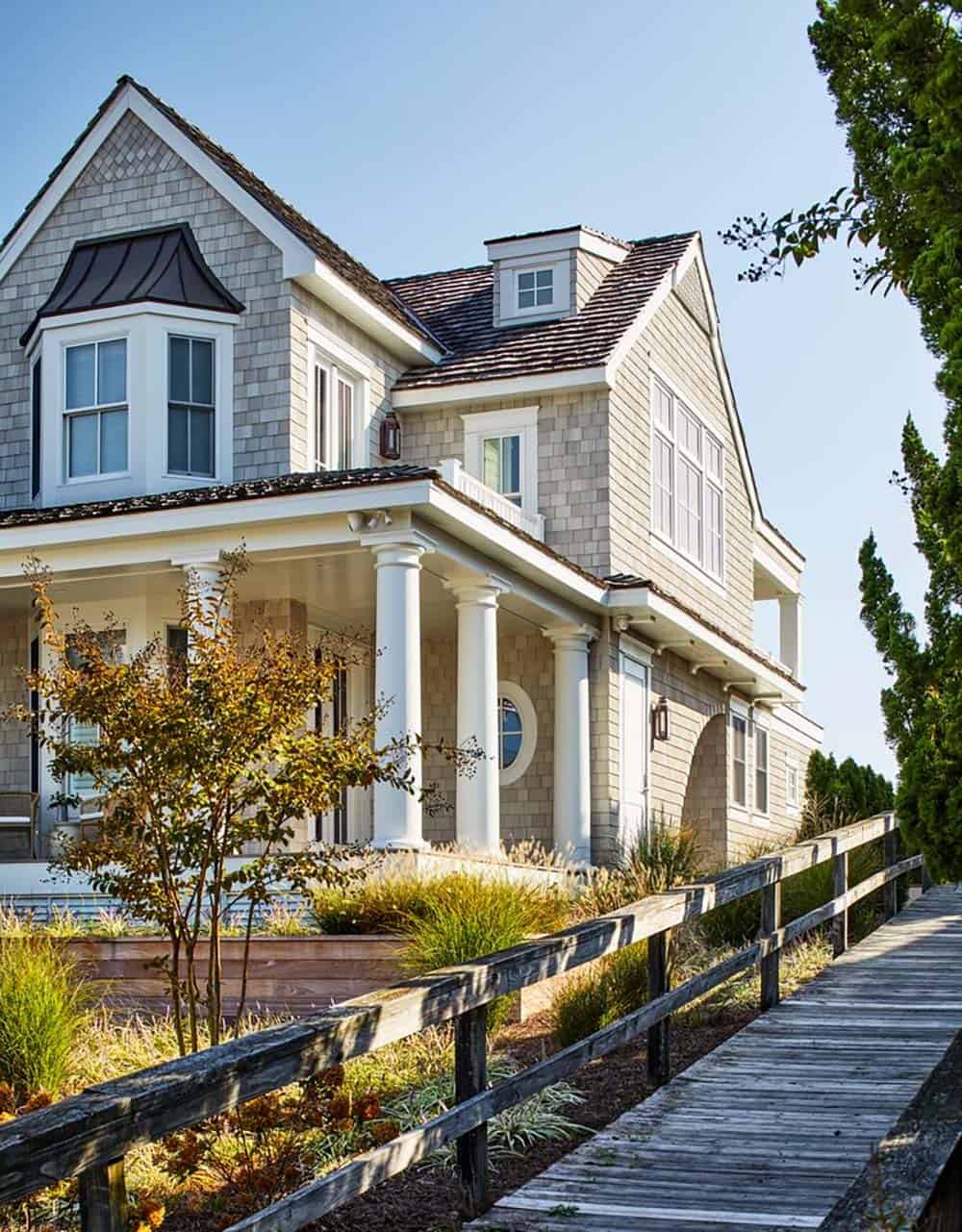 Shingle-style beach house with wraparound porch and boardwalk entrance