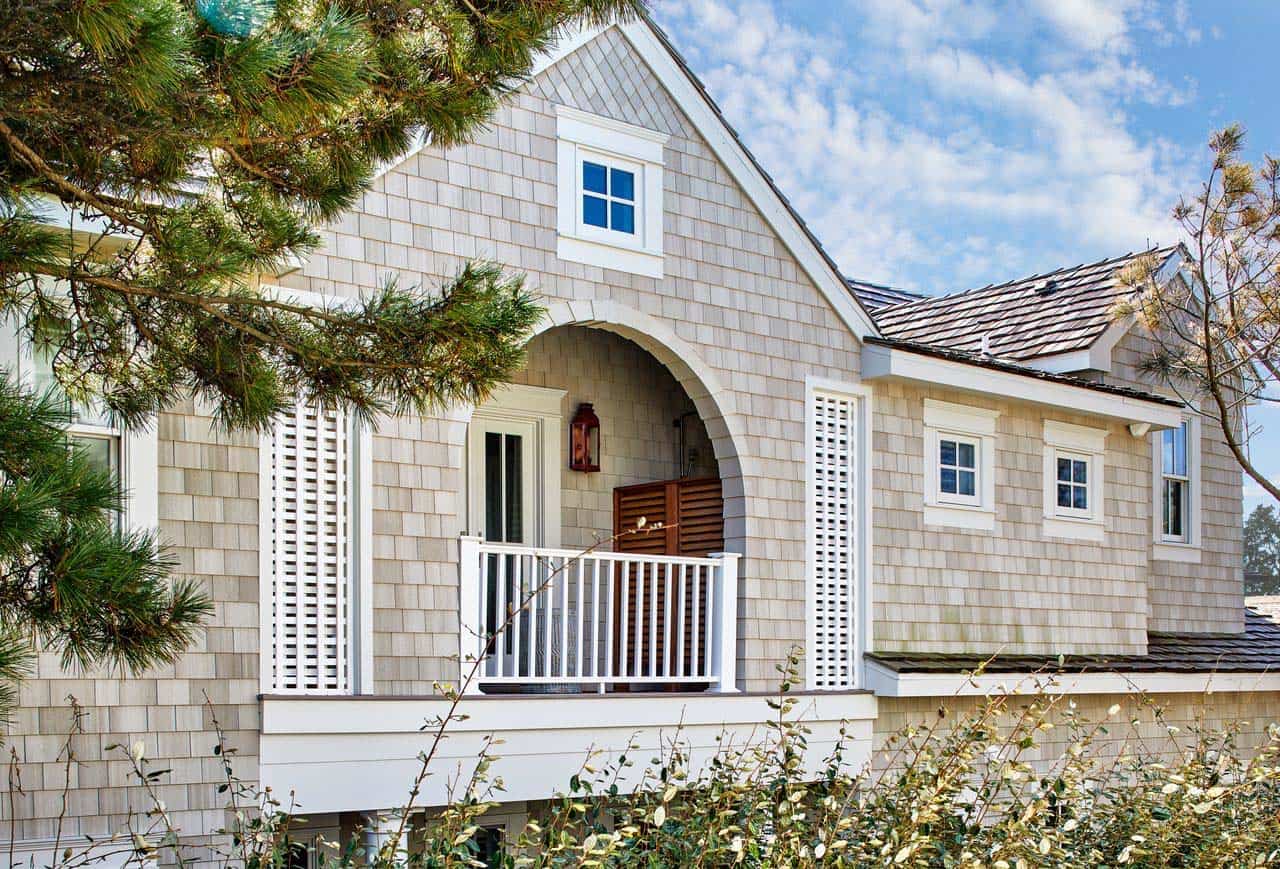 Second-story balcony with arched doorway and louvered privacy shutters