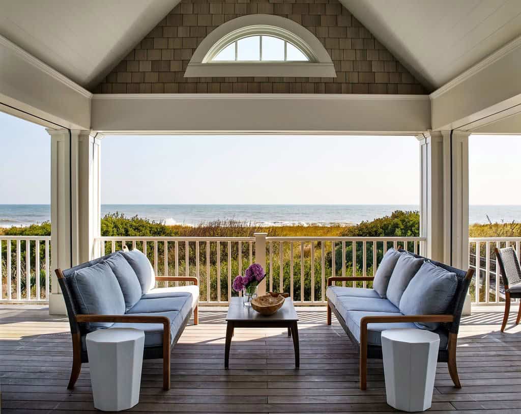 Covered porch with blue sofas overlooking the dunes and sea