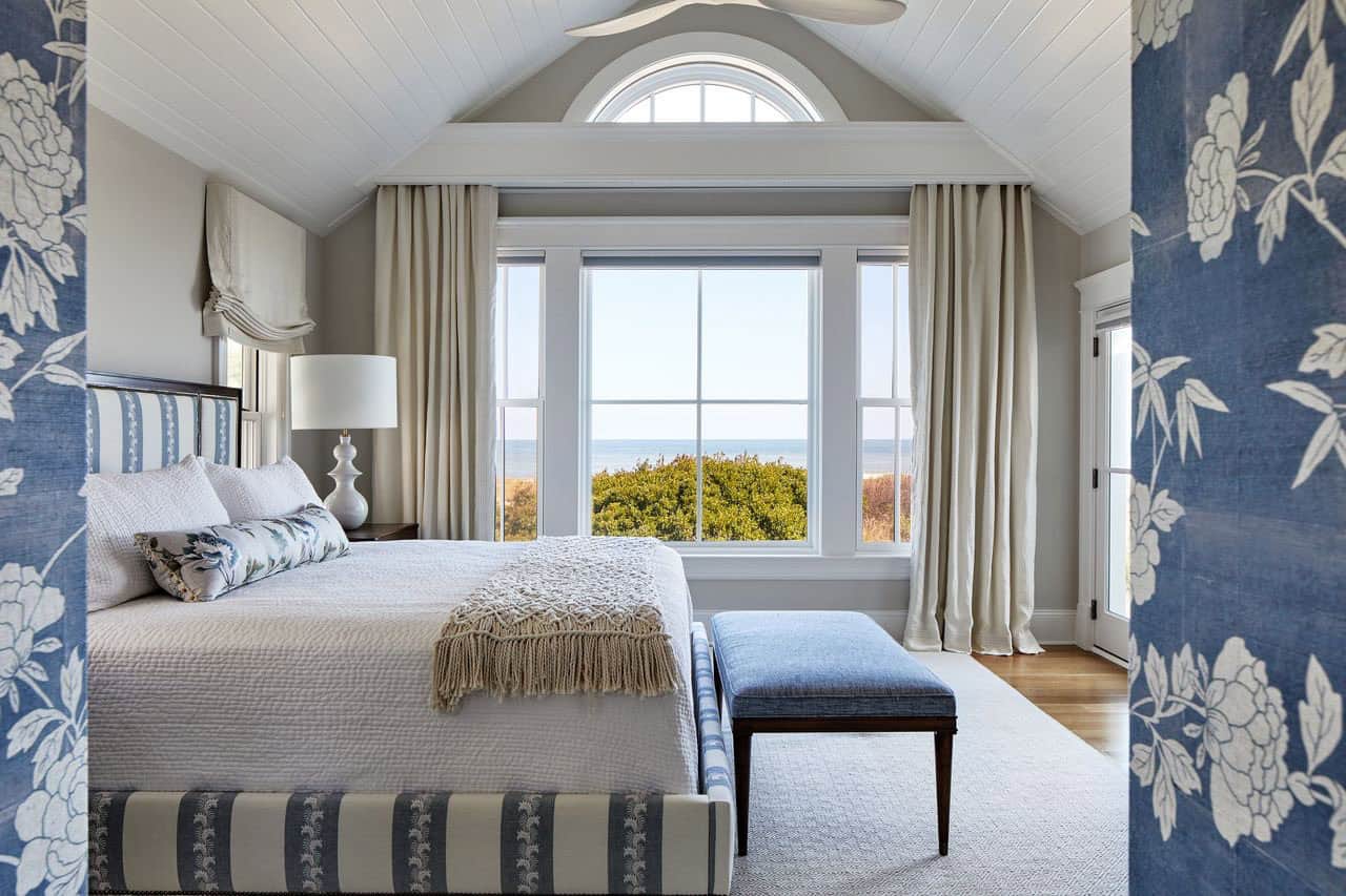 Primary bedroom with arched window framing the ocean view