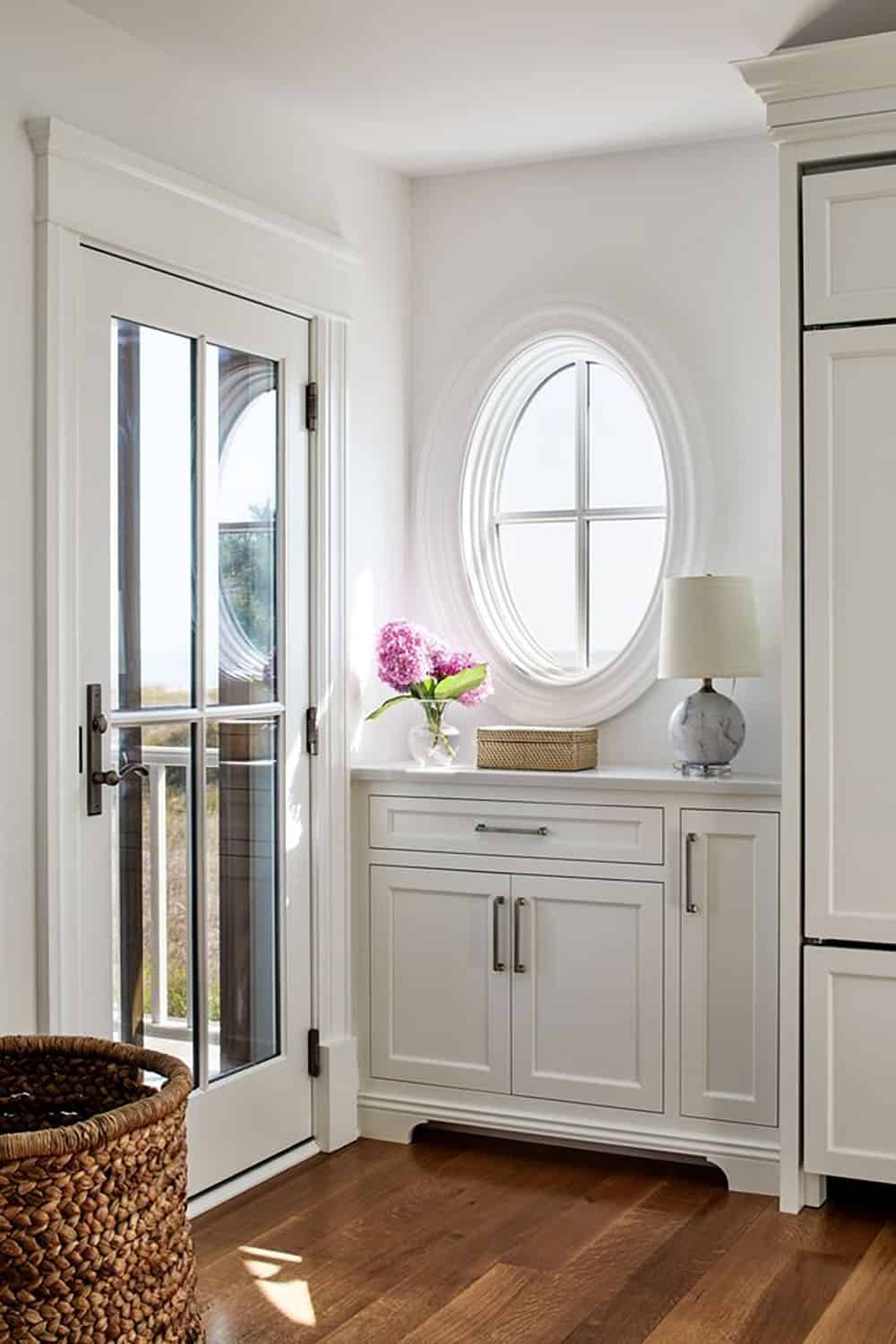 Mudroom nook with oval window and marble-topped storage cabinet