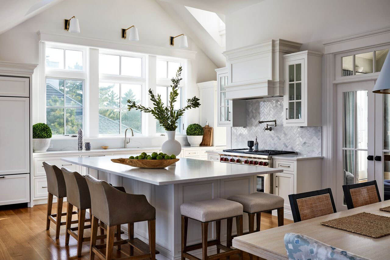 Vaulted white kitchen with island and herringbone tile backsplash