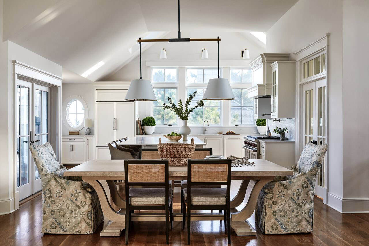 Dining table with patterned chairs beneath vaulted beamed ceiling