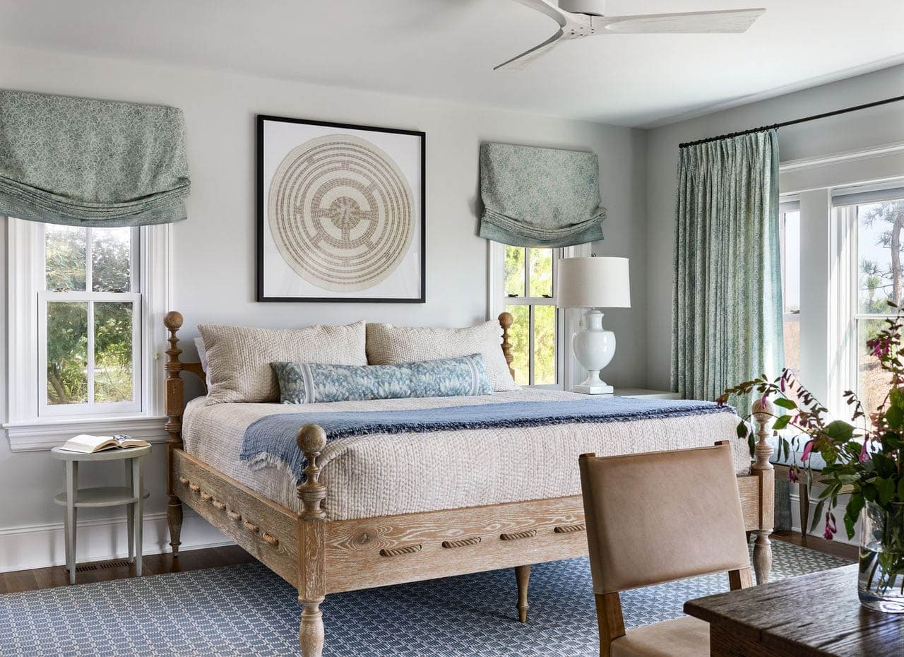Guest bedroom with rope bed frame and sage roman shades