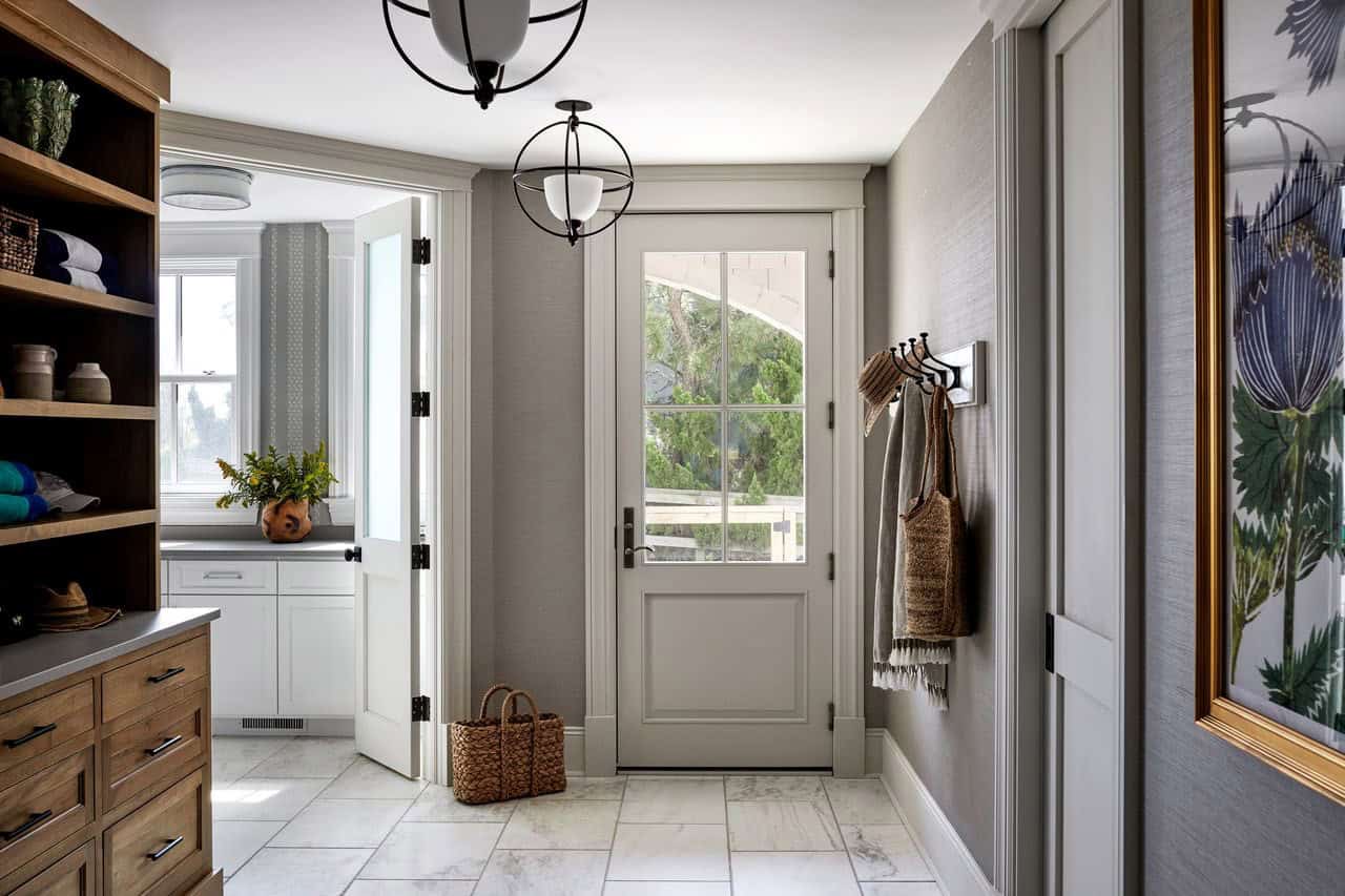 Mudroom entry with hooks, woven baskets, and floral art