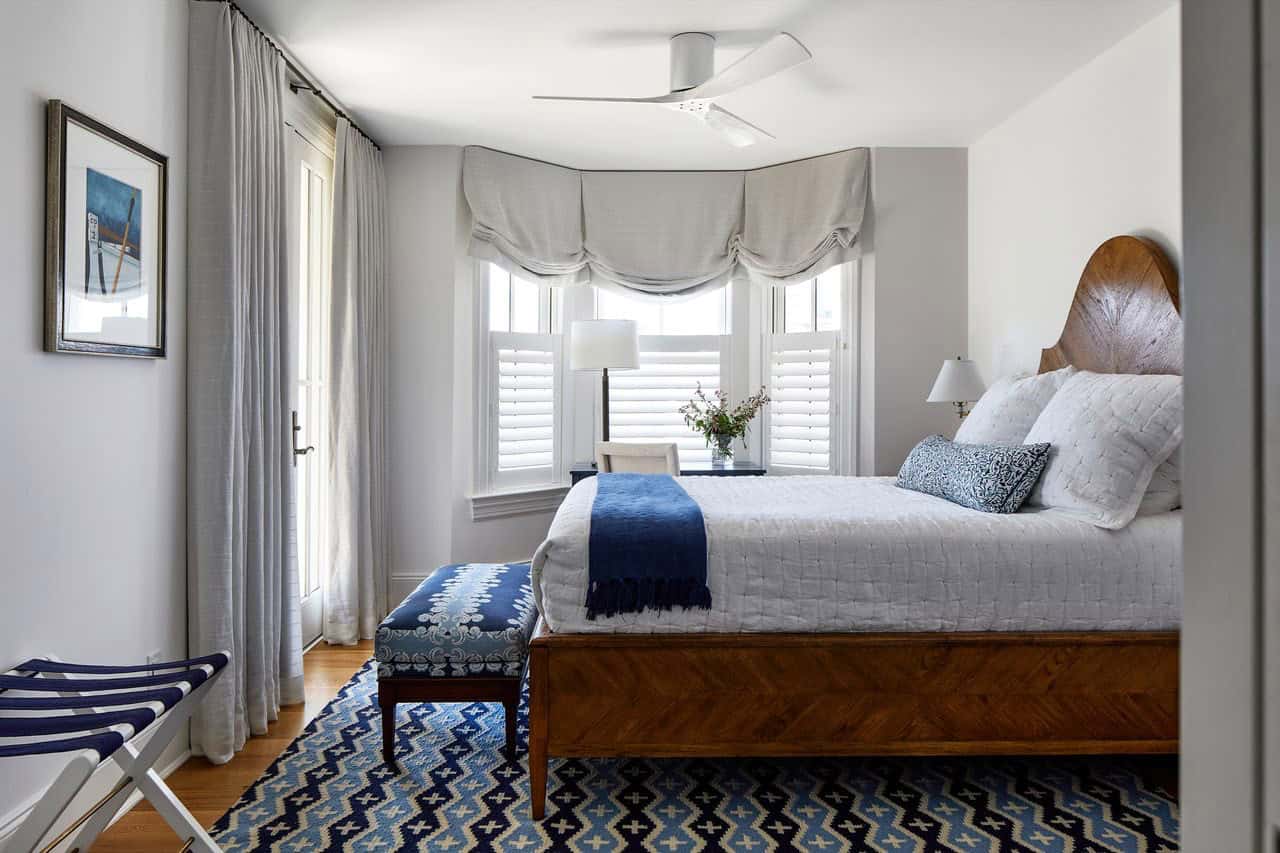 Bedroom with carved wood headboard and indigo ikat area rug