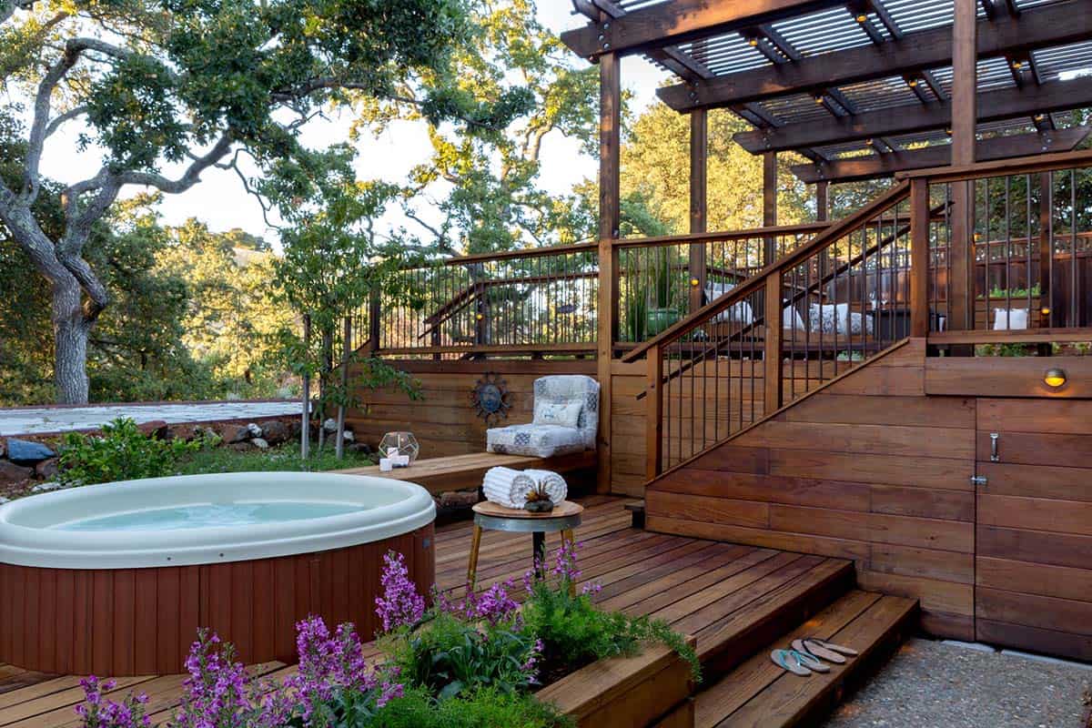 Multi-tiered wood deck in Berkeley, California with round hot tub, pergola, and built-in bench seating