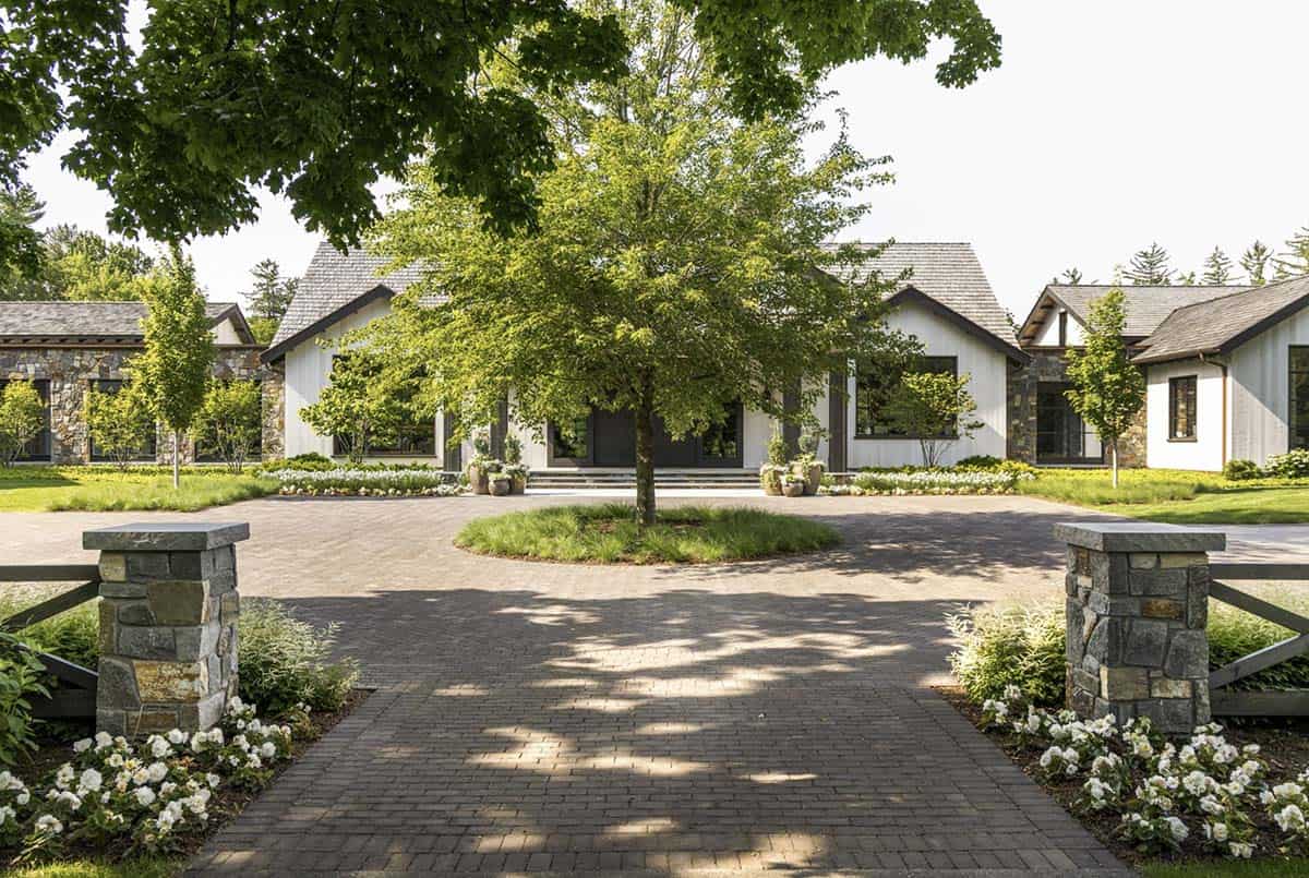Circular paver motor court with center tree leading to the home's main entrance