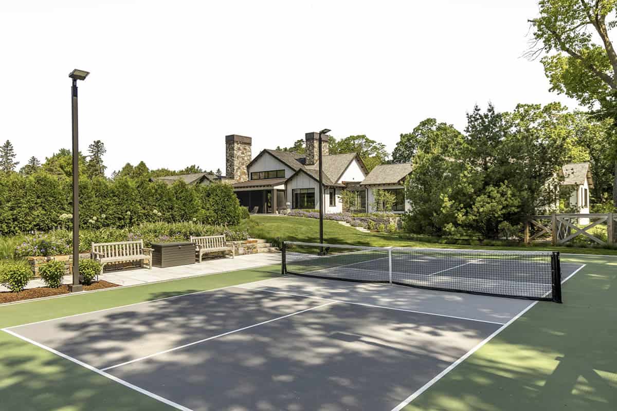 Sport court with bench seating and view back toward the home's gabled exterior