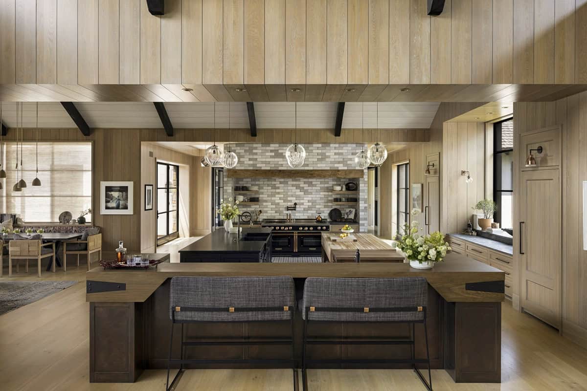 Kitchen with wood island, tile range hood, globe pendant lights, and dining nook